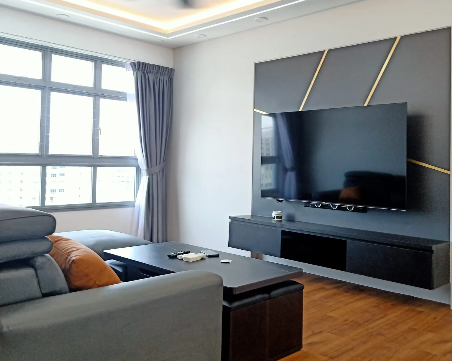 A finished living room with a panelled TV wall, photographed after handover